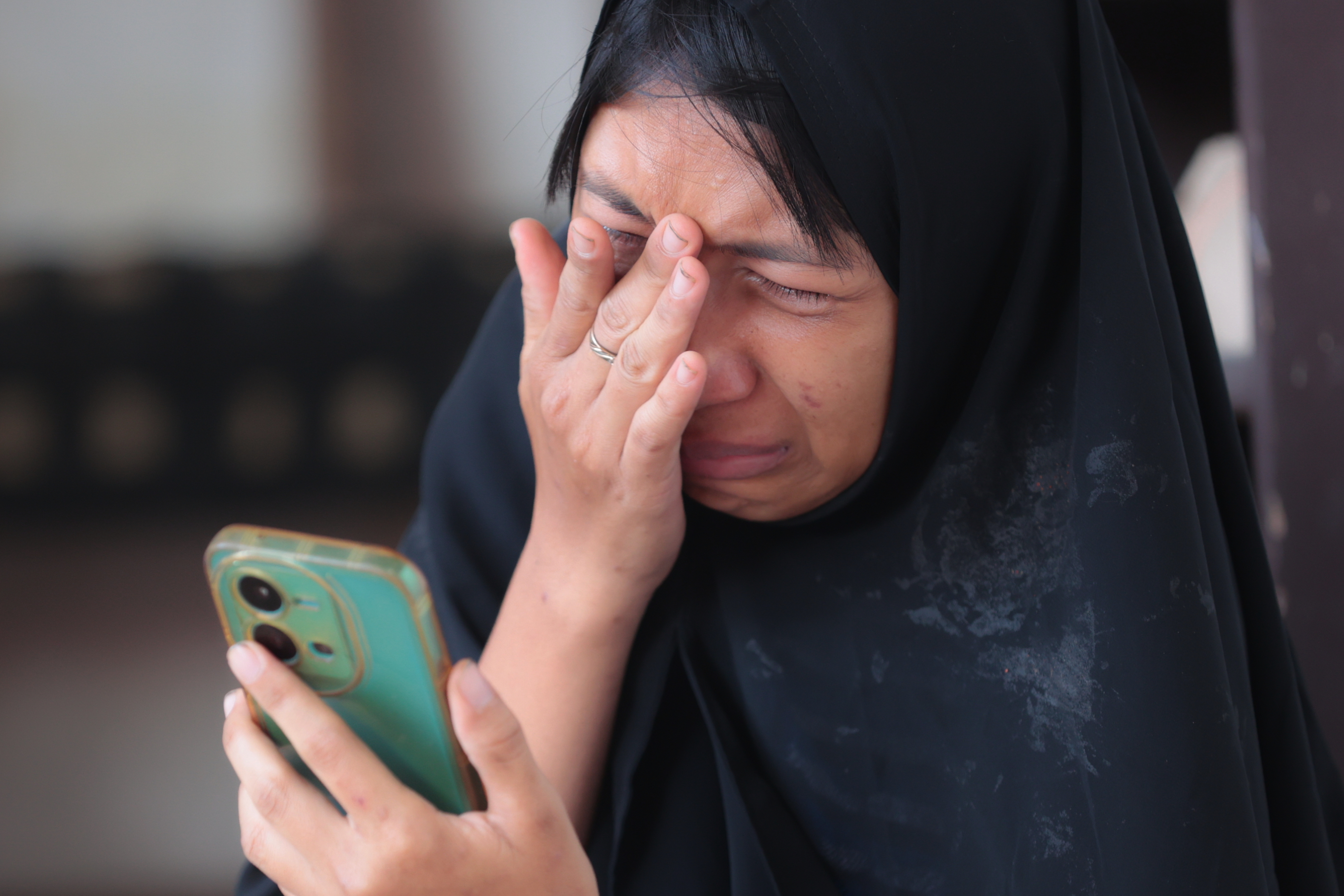 A woman weeps as rescue works are underway for victims trapped under the rubble after a building under construction collapsed at an Islamic boarding school in Sidoarjo, Indonesia. (AP)